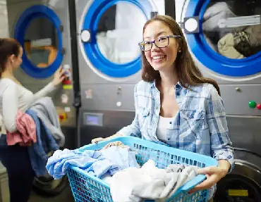 girl holding basket full of clothes